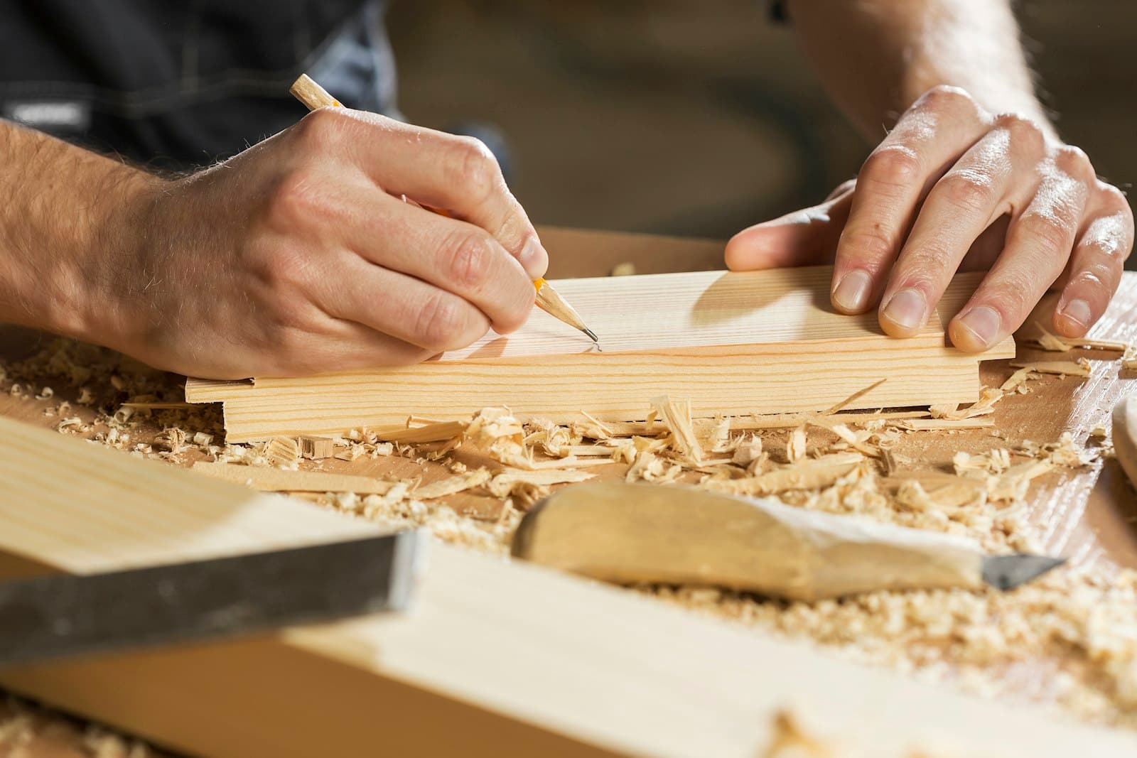 A carpenter marking out timber on the bench mid-job