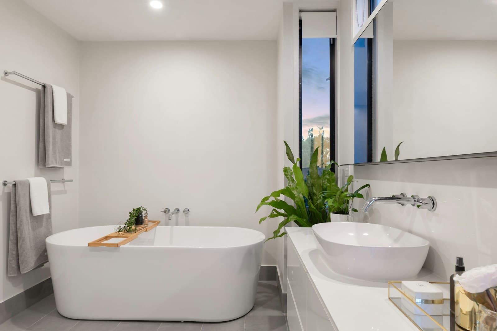 A renovated bathroom with a white bath and tiled walls