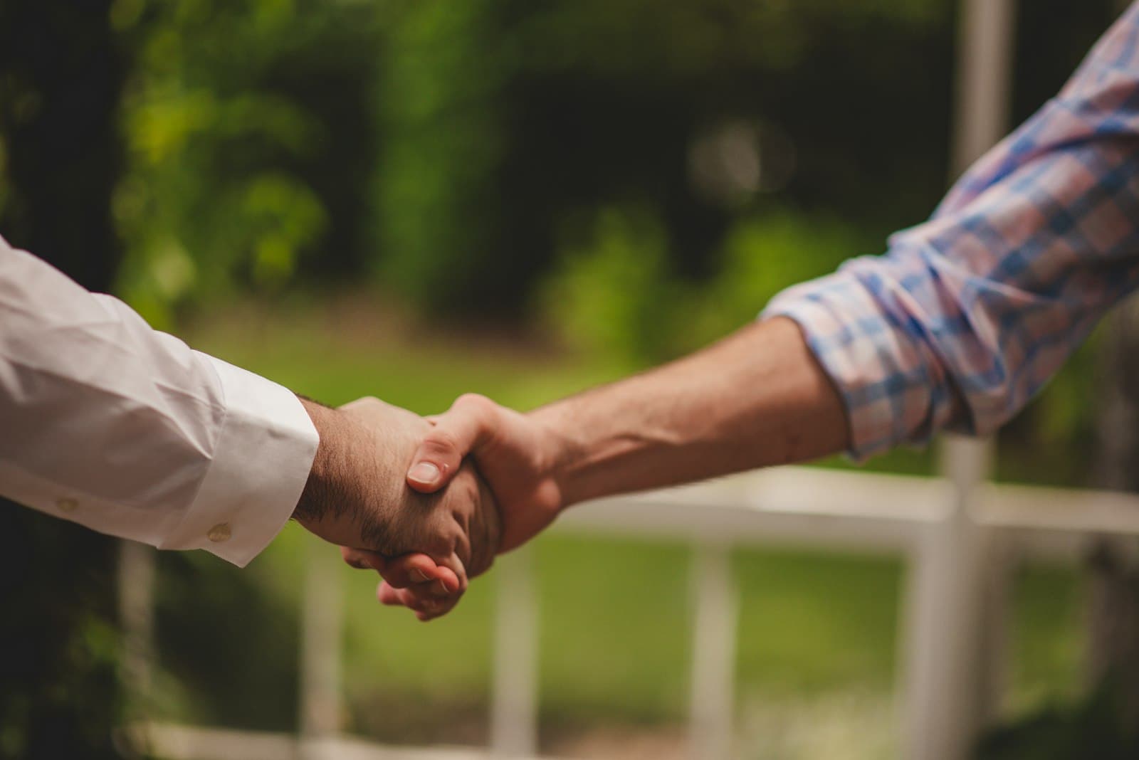 A homeowner and tradie shaking hands outdoors