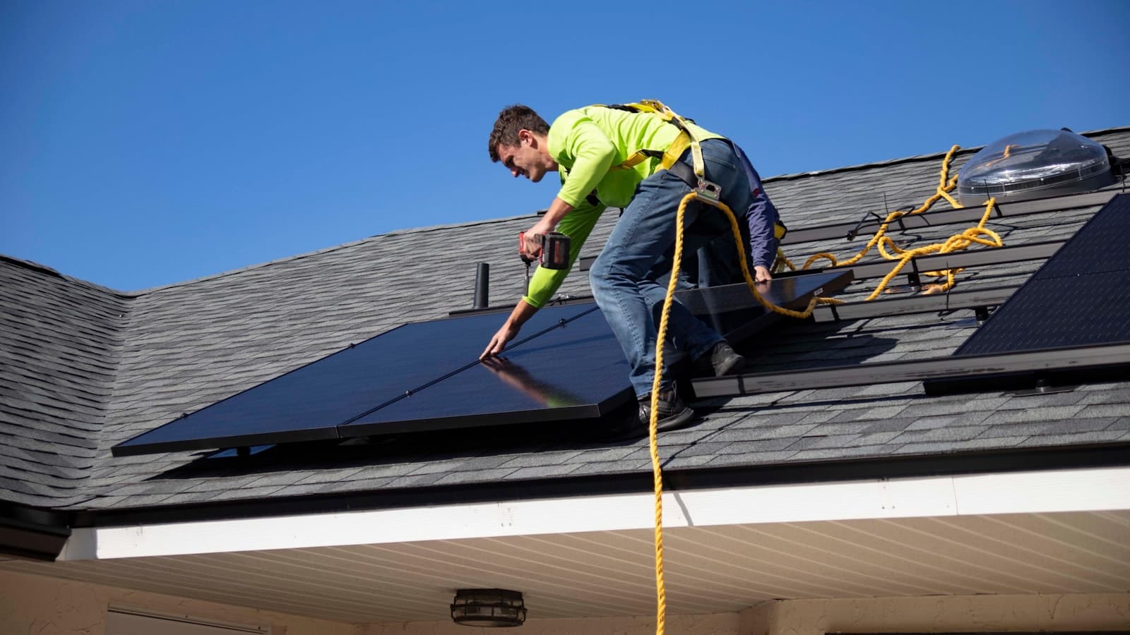Rooftop solar panels being cleaned on a residential roof