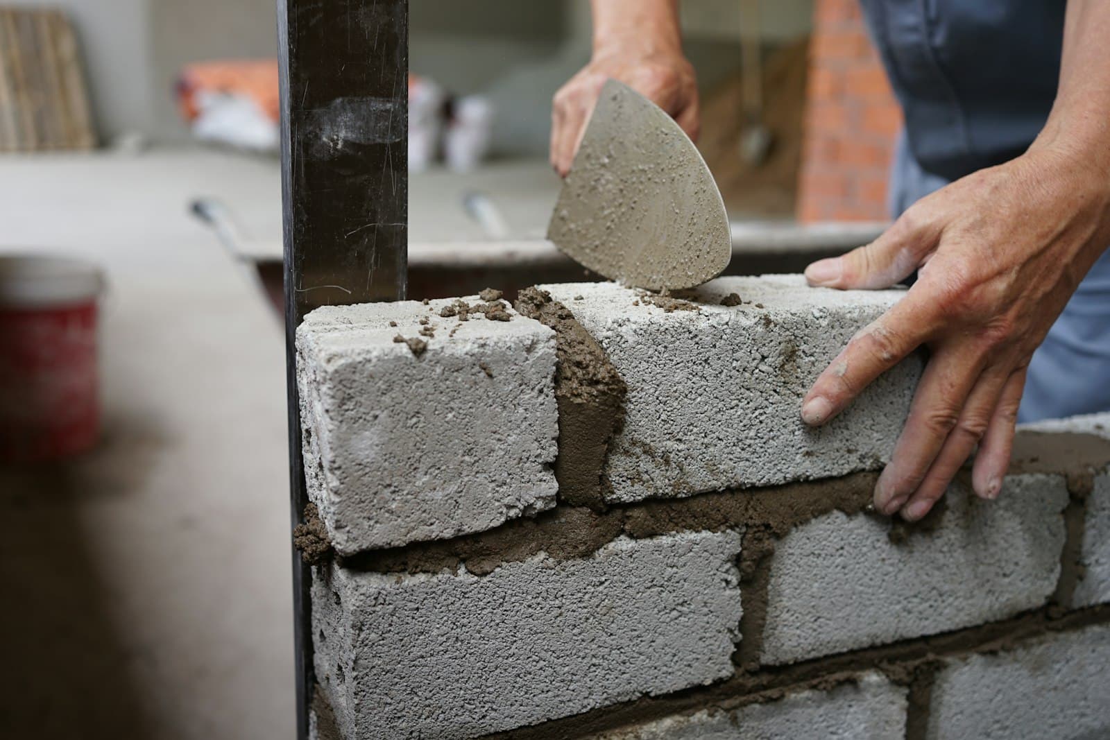 A bricklayer laying a course of bricks with mortar